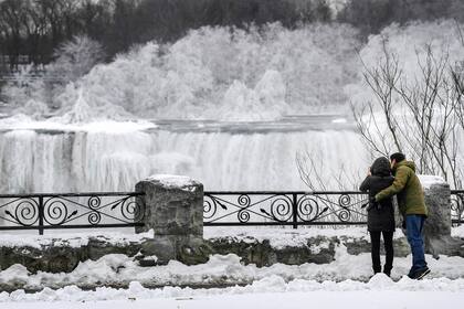 Una pareja toma una foto de las Cataratas del Niágara, congeladas debido a las bajas temperaturas, en Ontario, Canada.