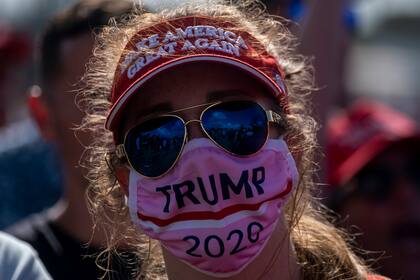 Una partidaria con una máscara de Trump 2020 escucha al presidente de Estados Unidos, Donald Trump, hablar durante un mitin de la campaña Make America Great Again en Tampa, Florida, el 29 de octubre de 2020