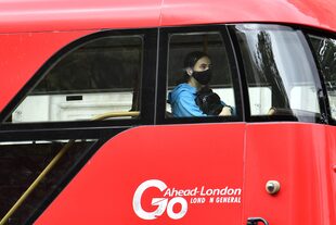 Una pasajero con barbijo en un ómnibus en Londres (Photo by JUSTIN TALLIS / AFP)