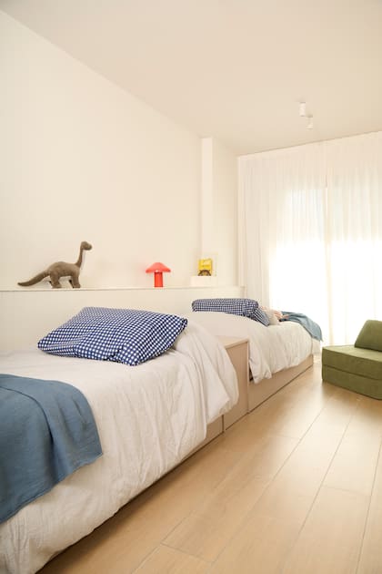 Una pequeña repisa para objetos recorre el largo del cuarto. Sillón ‘Milo’ verde (Loom Haus).