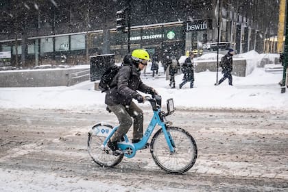 Una persona anda en bicicleta durante la nevada, ayer en Chicago,.