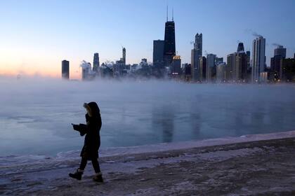 Una persona camina a lo largo de la orilla del lago, el 30 de enero, en Chicago. El vórtice polar cubrió el Medio Oeste estadounidense con temperaturas récord el miércoles, desencadenando cierres generalizados de escuelas y negocios, e impulsando al Servicio Postal de los Estados Unidos a dar el rar
