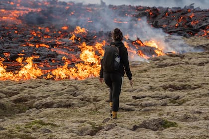 Una persona camina cerca de la lava que emerge de una fisura del volcán Fagradalsfjall cerca de la montaña Litli-Hrútur, el lunes 10 de julio de 2023