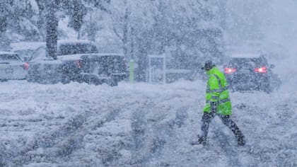 Una persona camina por un estacionamiento cubierto de nieve durante una tormenta, el jueves 1 de febrero de 2025, en Truckee, California. (AP Foto/Brooke Hess-Homeier)