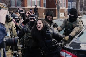 Una persona es detenida por agentes federales cerca del lugar donde Renee Good fue fatalmente baleada por un oficial del ICE la semana pasada, el 13 de enero de 2026