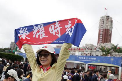 Una persona posa con una bandera con la frase "Tiempo del honor" durante las celebraciones del Día Nacional, frente al edificio presidencial, en Taipéi, Taiwán, el 10 de octubre de 2024.