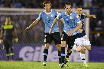 Una postal del último partido de Argentina sin los rosarinos: derrota por 3-2 ante Uruguay por las Eliminatorias, en el Centenario; en la imagen, Diego Lugano y Diego Godín luchan por la pelota con Sebastián Domínguez