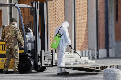 Una rampa es desinfectada luego que los militares transportaran los cuerpos, en Seriate