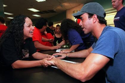 Enrique Iglesias charla con una fan, durante un encuentro en Montebello, California, el 25 de noviembre de 1997