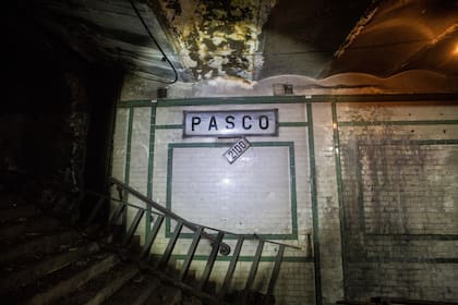 El cartel que indica la altura de calle Rivadavia cuelga debajo del cartel de la estación Pasco abandonada