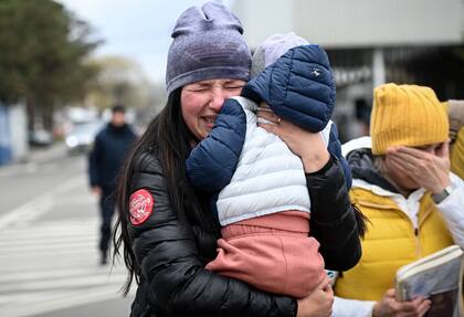 Una refugiada ucraniana con su hijo en brazos llora al llegar al paso fronterizo de Siret, entre Rumania y Ucrania, el 18 de abril de 2022.