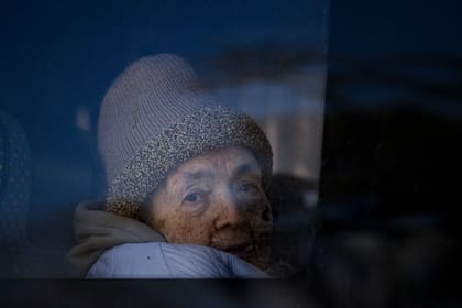 Una refugiada ucraniana que huye de la guerra mira por la ventana de un micro tras cruzar la frontera entre Rumania y Ucrania, el lunes 14 de marzo de 2022, en Siret, Rumania