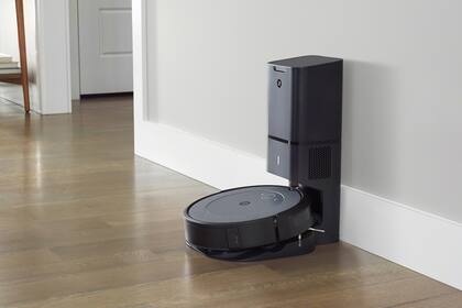 Una Roomba i3 con la base de carga y el depósito para la suciedad; este último es opcional y reduce la frecuencia con la que hay que vaciar la Roomba