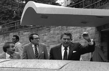 Una secuencia muestra al presidente inicialmente saludando y luego siendo empujado rápidamente hacia su limusina por agentes del Servicio Secreto tras los disparos. (Ron Edmonds - Associated Press)