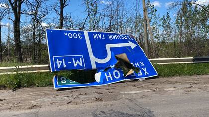 Una señal destruida por los bombardeos que indica que Kherson queda a pocos kilómetros