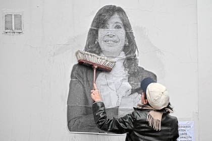Una simpatizante de la expresidenta pega un cartel frente a su departamento de Constitución