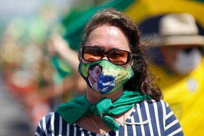 Una simpatizante del presidente brasileño, Jair Bolsonaro, usa una máscara mientras se manifiesta contra las medidas de cuarentena y distanciamiento social impuestas por los gobernadores y alcaldes para combatir el nuevo brote de coronavirus en Brasilia el 19 de abril de 2020