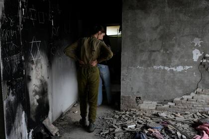 Una soldado israelí observa una casa marcada por la batalla en el kibutz Be'eri, una granja comunal israelí en la frontera con Gaza, en el primer aniversario del ataque de Hamas contra Israel el lunes 7 de octubre de 2024
