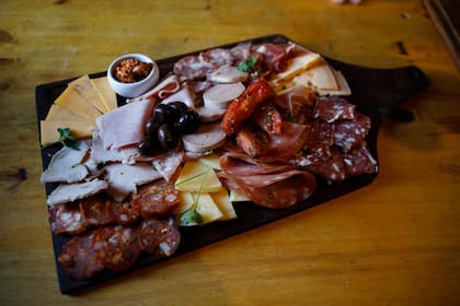 Una tabla con variedad de fiambres y quesos