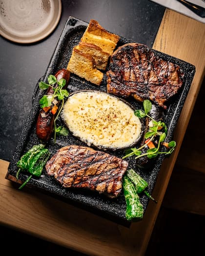 Una tabla para compartir, con morcilla, provoleta y carne.