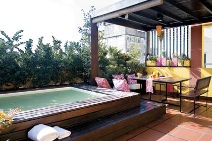 Una terraza que aprovecha el color y el espacio para lograr un ambiente vital y práctico. Para resguardo del sol, la mesa y los bancos se ubicaron en la galería, complementada con esterillas enrollables