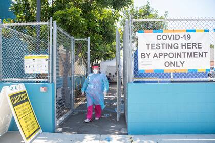 Una trabajadora de la salud se para en la entrada de un sitio de prueba de coronavirus en el Centro de Niños y Familias de San Juan Sano, el 24 de julio de 2020, en Los Ángeles, California