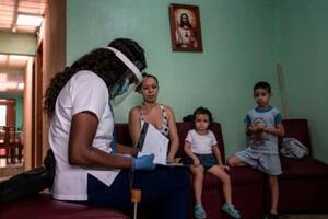 Una trabajadora del sector de la salud le daba información, en julio de 2020, a una familia sobre la prueba de detección de covid-19, en su hogar
