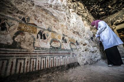 Una arqueóloga cepilla las paredes pintadas de la Tumba TT28, que originalmente databa del Reino Medio (siglos XXI-XVIII), pero fue reutilizado en el período Tardío (siglos VII-IV)