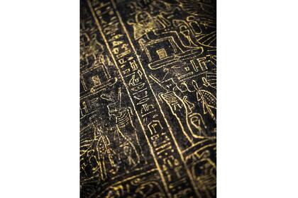 Jeroglíficos tallados en un sarcófago de madera negro con incrustaciones de hojas doradas, que datan del último período de Egipto (siglos VII-IV aC)
