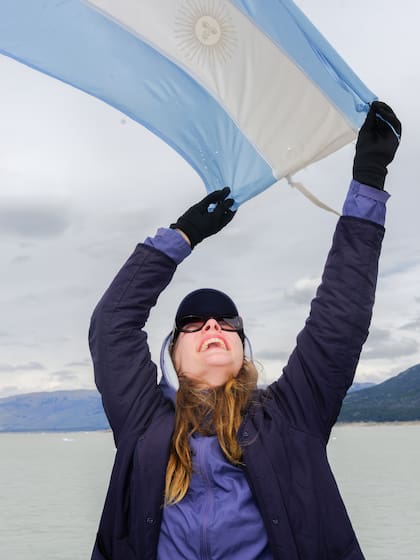 Una turista francesa sostiene la bandera argentina durante una navegación en el Perito Moreno