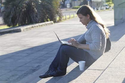Una usuaria se conecta a Internet de forma inalámbrica en la red Wi-Fi ubicada en las escalinatas de la Facultad de Derecho en Buenos Aires