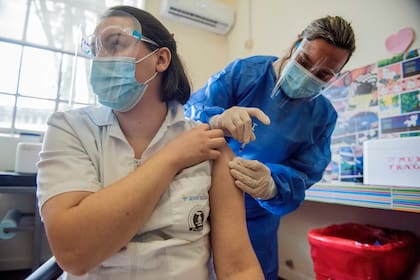 Una vacunadora recibe una inyección de la vacuna Sinovac contra el Covid-19 mientras el país vacuna a maestros, policías, bomberos y militares en actividad menores de 60 años contra el nuevo coronavirus en Montevideo