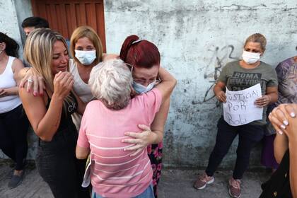 Una vecina abraza a Lorena Villafañe, hija mayor de la víctima; al lado, de negro, su hermana, Julieta