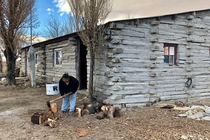 Una vecina de Mamuel Choique hachando leña