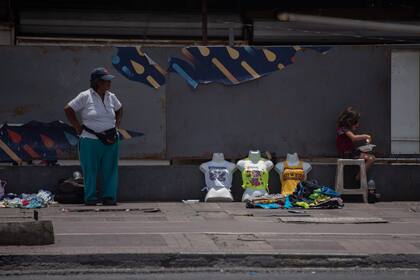 Una vendedora ambulante espera por clientes en una avenida, en Caracas, Venezuela, el 24 de julio de 2022.