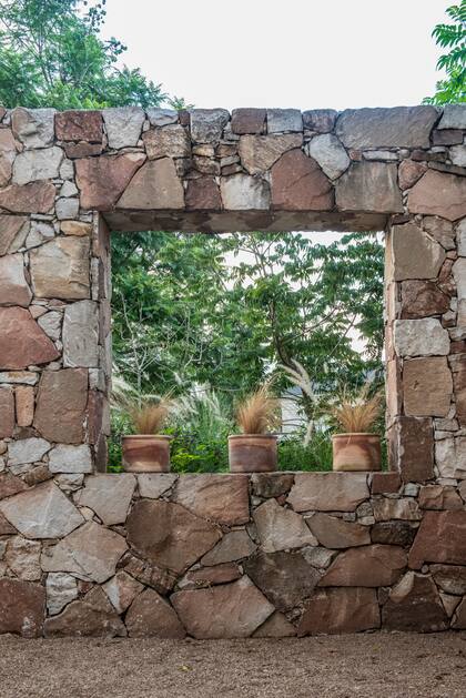 Una ventana al resto del jardín, con el mismo material que los muros de la casa..