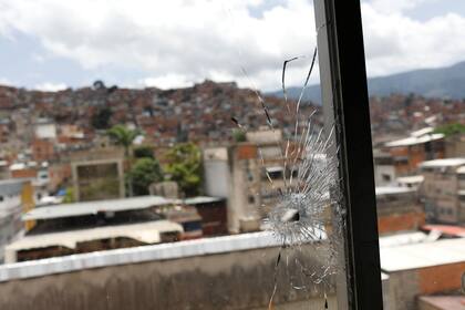 Una ventana golpeada por una bala se aprecia en las oficinas de la iglesia San Miguel Arcángel luego de enfrentamientos armados entre miembros de la banda criminal de El Koki y fuerzas policiales en el barrio El Cementerio, en Caracas, el 12 de julio de 2021