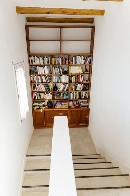 Una vieja biblioteca de sus años universitarios se modificó para cubrir una pared en la escalera que va a los dormitorios