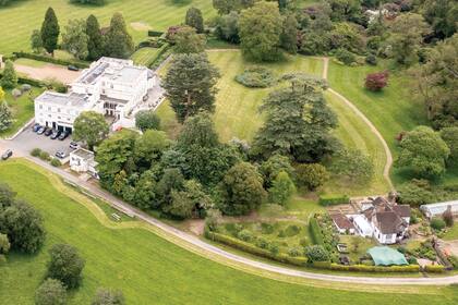 Una vista aérea de la propiedad, que tiene una capilla, pileta y un área de servicio.
