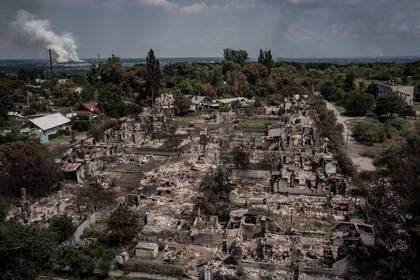 Una vista aérea muestra casas destruidas después de un ataque en la ciudad de Pryvillya en la región oriental de Ucrania de Donbass el 14 de junio de 2022, en medio de la invasión rusa de Ucrania. (Photo by ARIS MESSINIS / AFP)