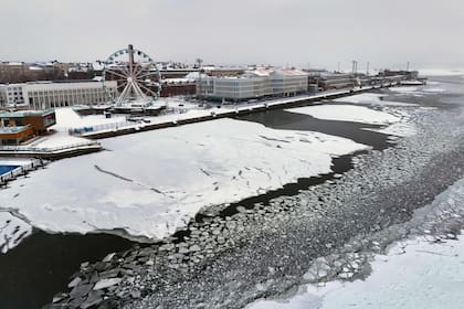 Una vista aérea tomada el 3 de enero de 2024 muestra nieve y hielo cubriendo la bahía cerca del área de Karajanokka con la noria SkyWheel de la capital finlandesa, Helsinki, mientras una ola de frío azotaba el país.