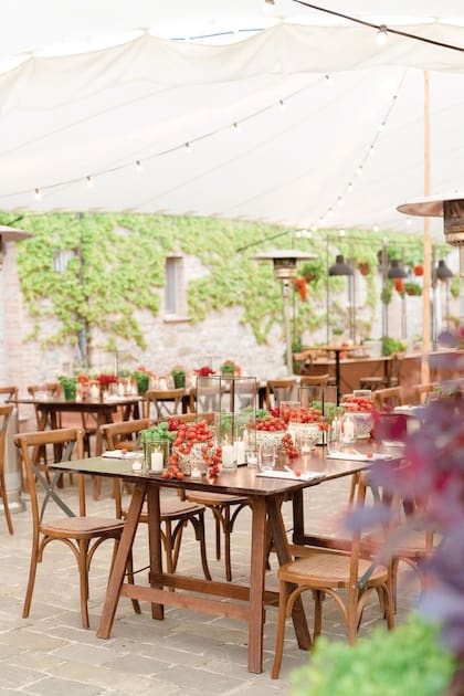 Una vista de la ambientación rústica con mesas y puestos de frutos, flores y helados en la celebración anterior a la boda.