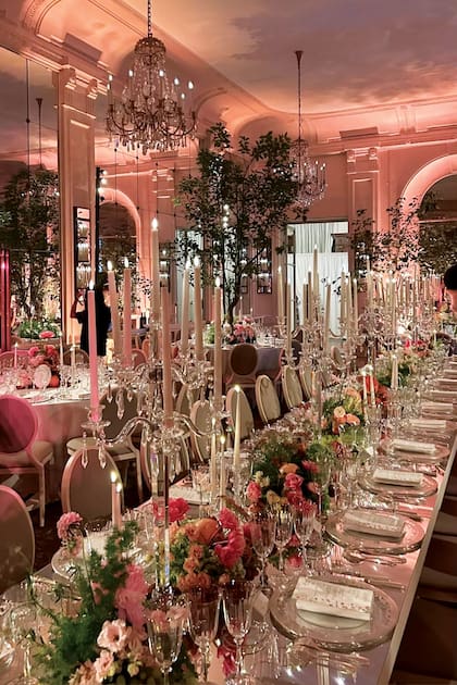 Una vista de la mesa principal, con flores, candelabros de cristal y platos de sitio de plata.