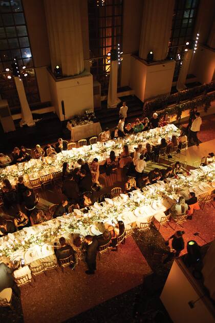 Una vista de las mesas estilo imperio decoradas con candelabros, flores y toques dorados.