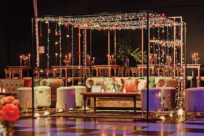 Una vista del living principal, estilo boho, adornado con flores y guirnaldas de luces. Había, para los demás invitados, livings con mesas altas. Cada rincón del salón Jano's, en Benavídez, fue decorado con cuadros y botellitas colgando de los árboles.
