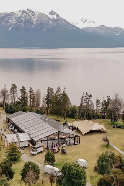 Una vista del predio donde se hizo la fiesta, con la enorme estructura del salón montado frente al lago Nahuel Huapi y las carpas con las barras de tragos y las islas de finger food.