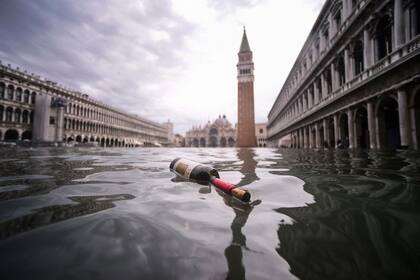 Una vista general muestra una botella de vino flotando en el agua de la inundada Plaza de San Marcos