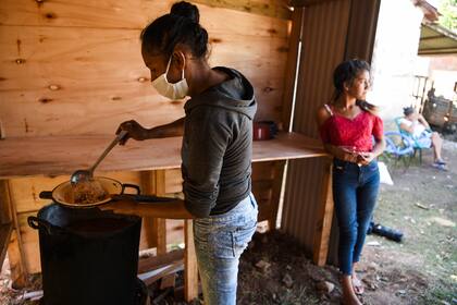 Una voluntaria con mascarilla sirve comida en un comedor de beneficencia en Asunción, el 16 de junio de 2020, en medio de la pandemia de coronavirus