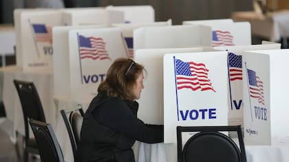 Una votante llena su boleta para las elecciones primarias de Michigan en Grosse Pointe Farms, Michigan, el martes 27 de febrero de 2024