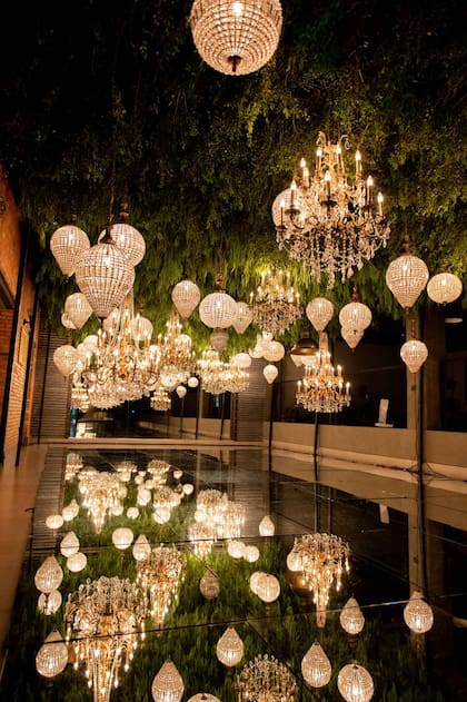 Unas 200 esferas espejadas y hojas amazónicas en un espacio se sirvió la mesa de dulces y la estación de café con trufas y naranjitos.